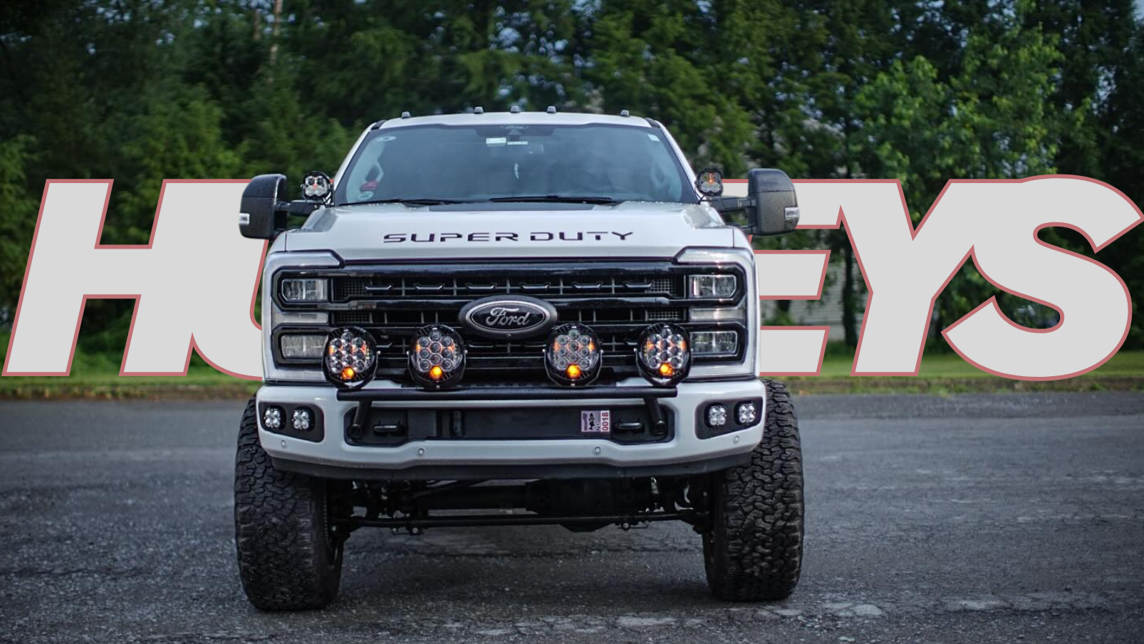 Ford Super Duty truck in front of a large 'Holley' sign.