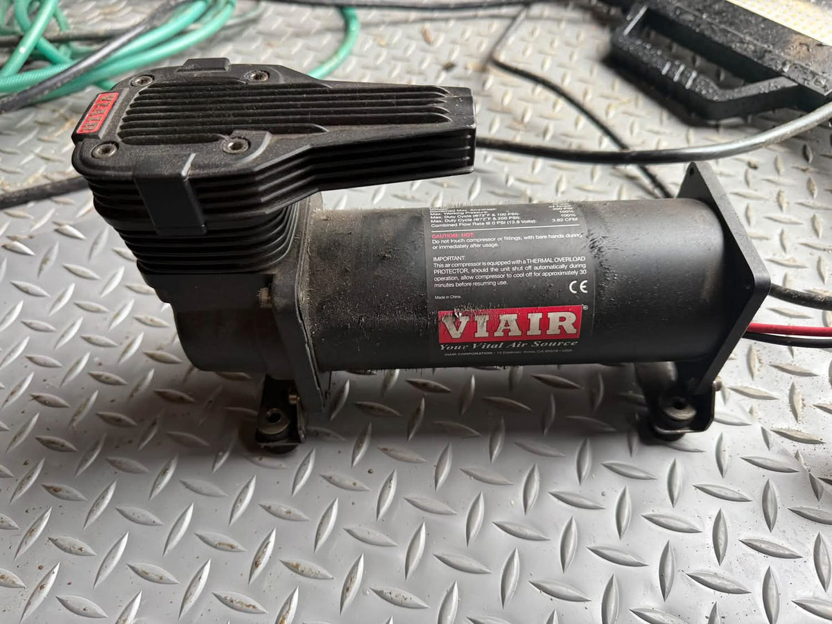 Black VIAIR air compressor on a diamond plate work surface.