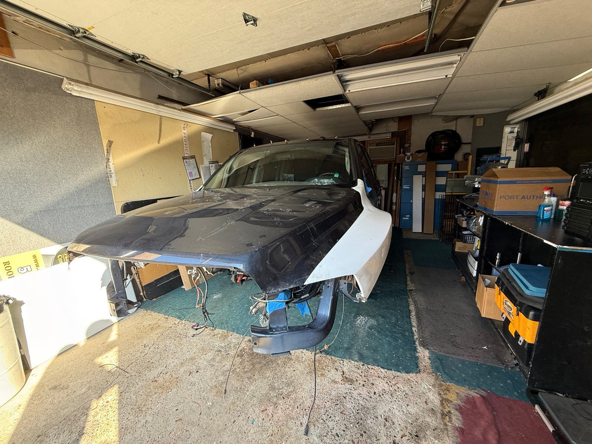 Wide view of THE DUALLY cab and white fiberglass fenders during bodywork mockup at Hurrey’s Performance.